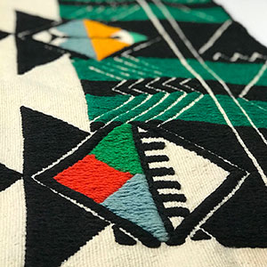 detail of Hopi weaving with geometric diamond pattern design and yarns in red, green, blue, black, and white